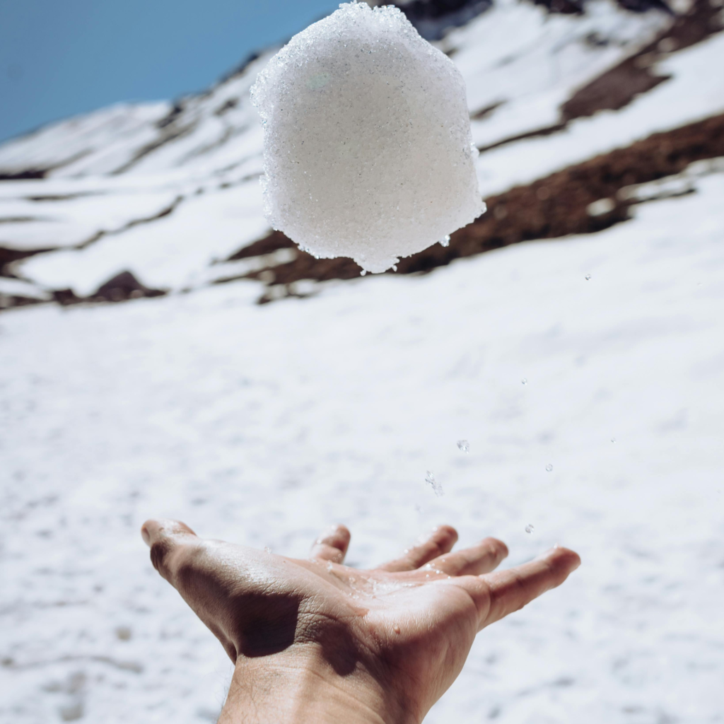 a man throwing a snowball in the air